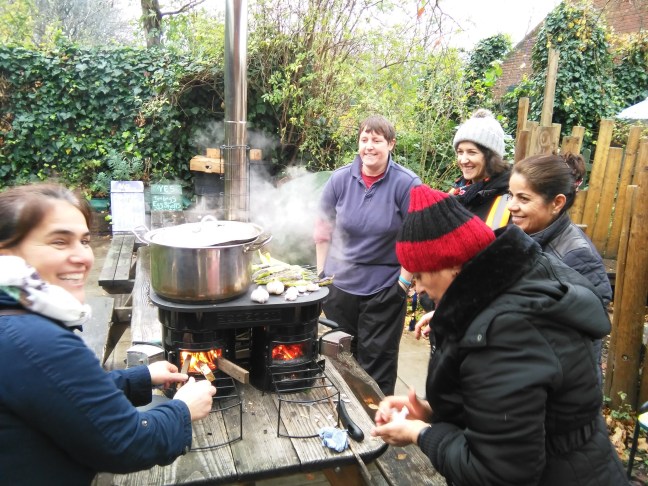 Four people cooking on the Ecozoom La Plancha stove